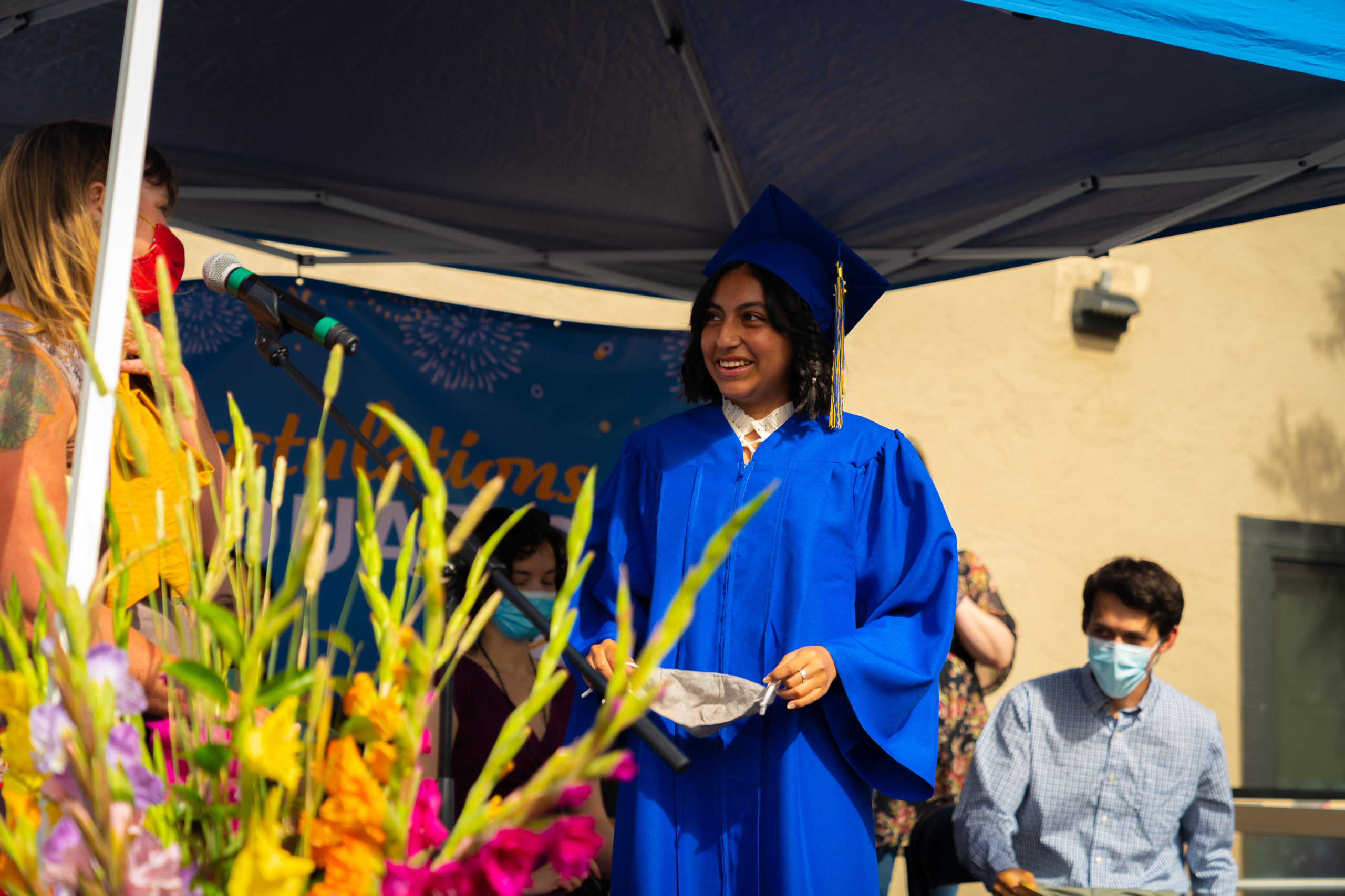 student at graduation with plants in foreground